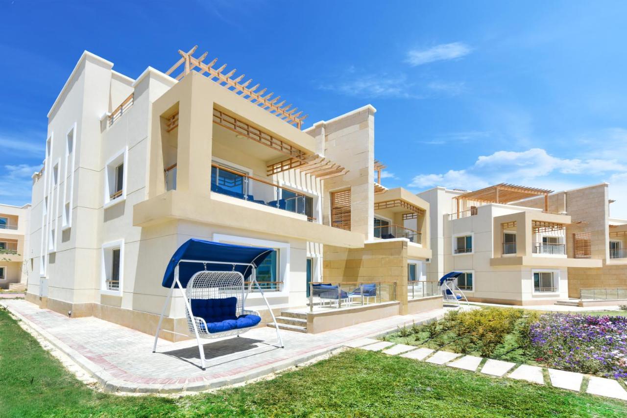 Tolip Resort El Galala Majestic Ain Sukhna Ngoại thất bức ảnh The photo displays a modern residential complex featuring two or more white buildings with a contemporary architectural design. Each building has balconies, large windows, and a sunshine-friendly layout that maximizes natural light. In the foreground