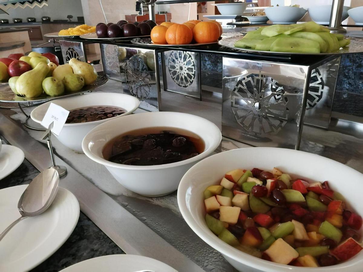 Tolip Resort El Galala Majestic Ain Sukhna Ngoại thất bức ảnh The photo shows a buffet-style arrangement of various fruits and fruit dishes. In the foreground, there are several bowls containing different types of fruit. One bowl has a fruit salad made with diced apples, green apples, and possibly other fruits.